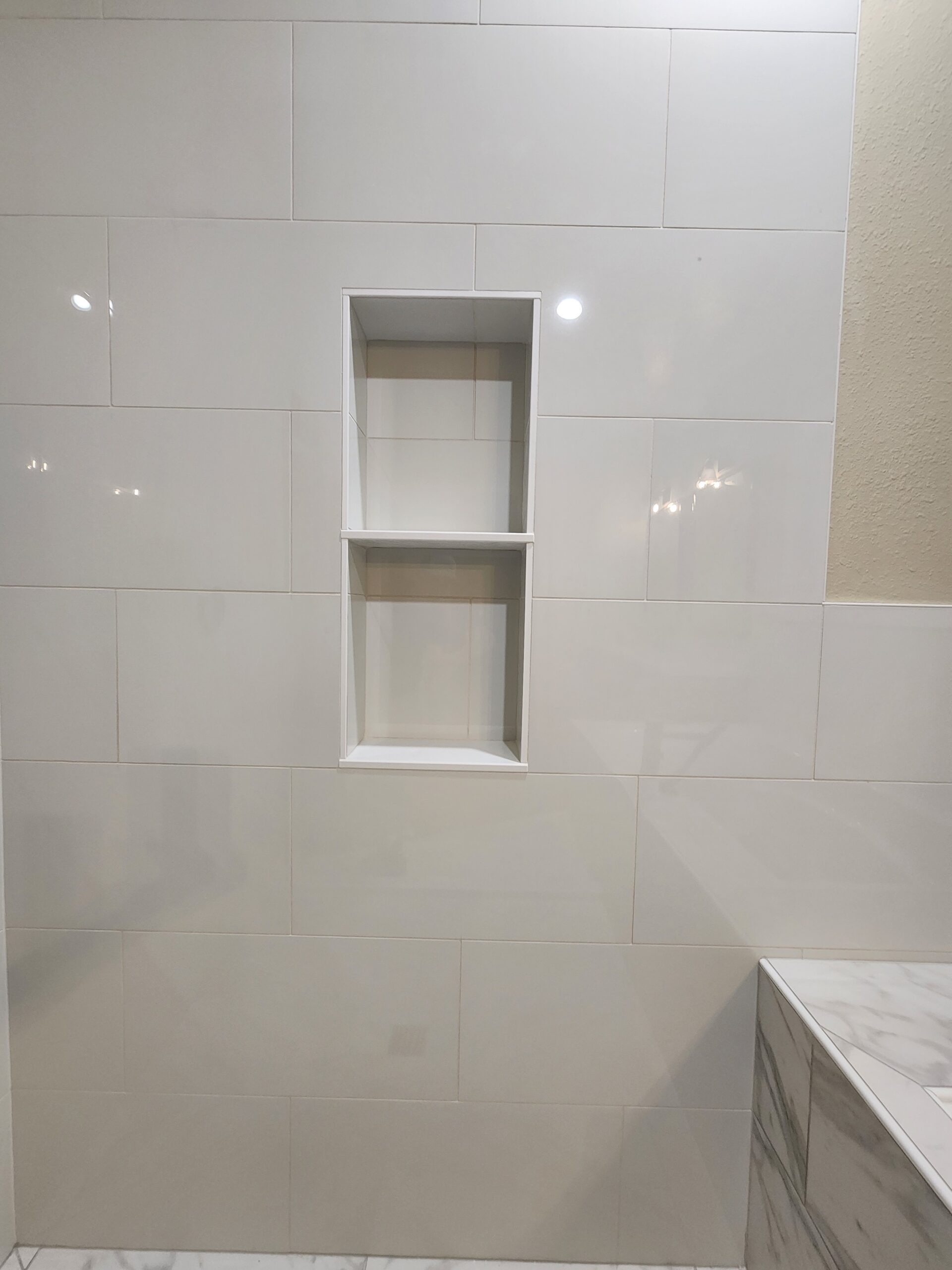Built-in tile shelving and storage niche in a bathroom remodel