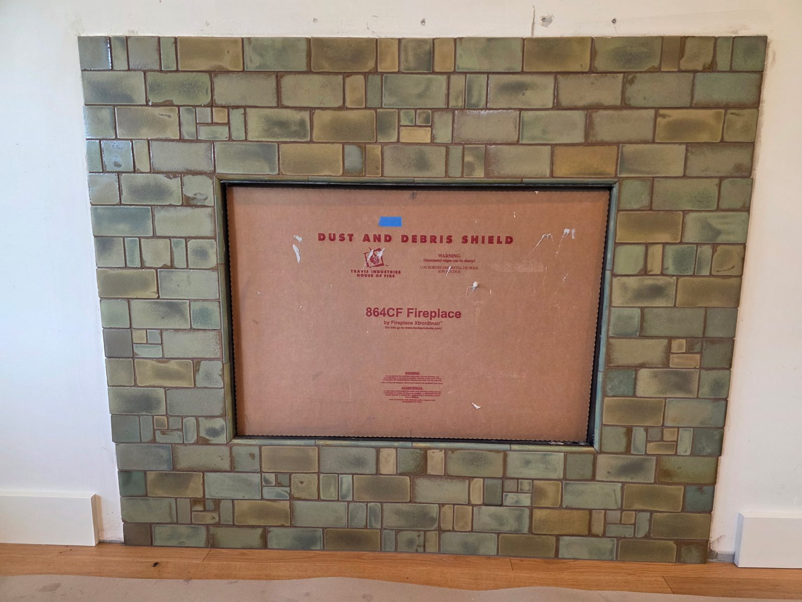 Olive-green handmade tile fireplace surround during installation
