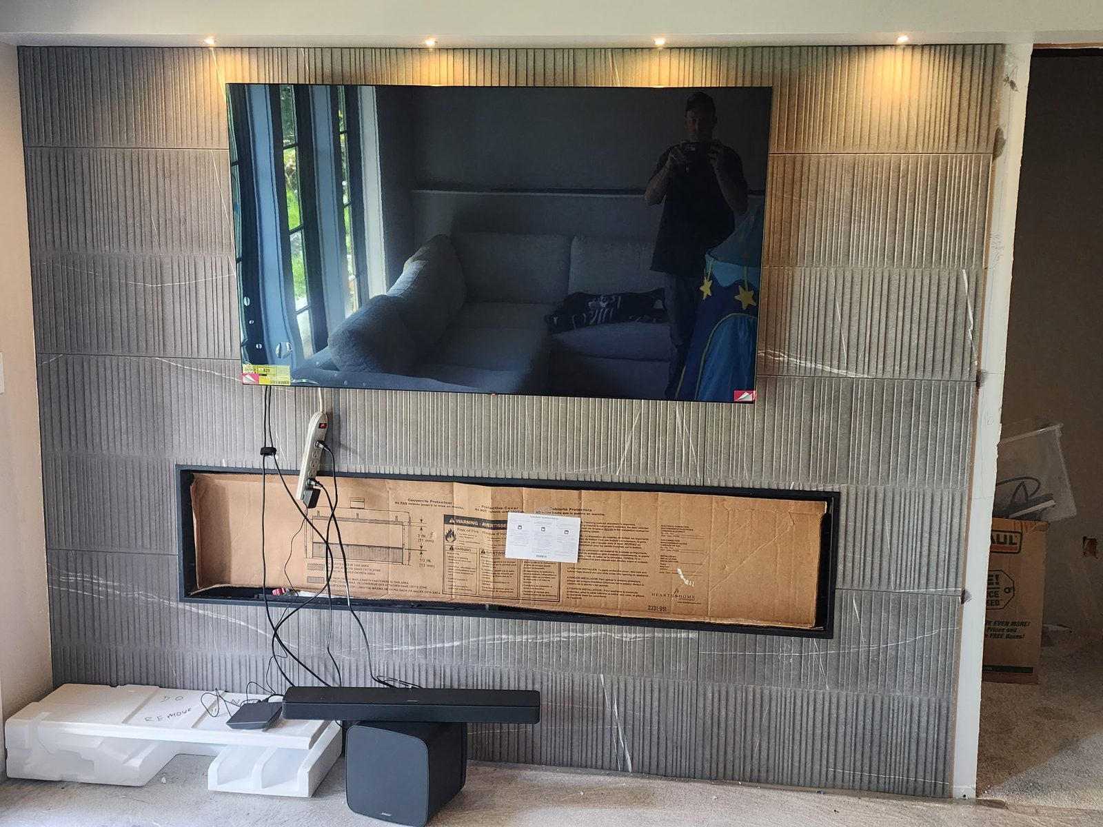 Gray linear tile feature wall with recessed linear fireplace and mounted TV