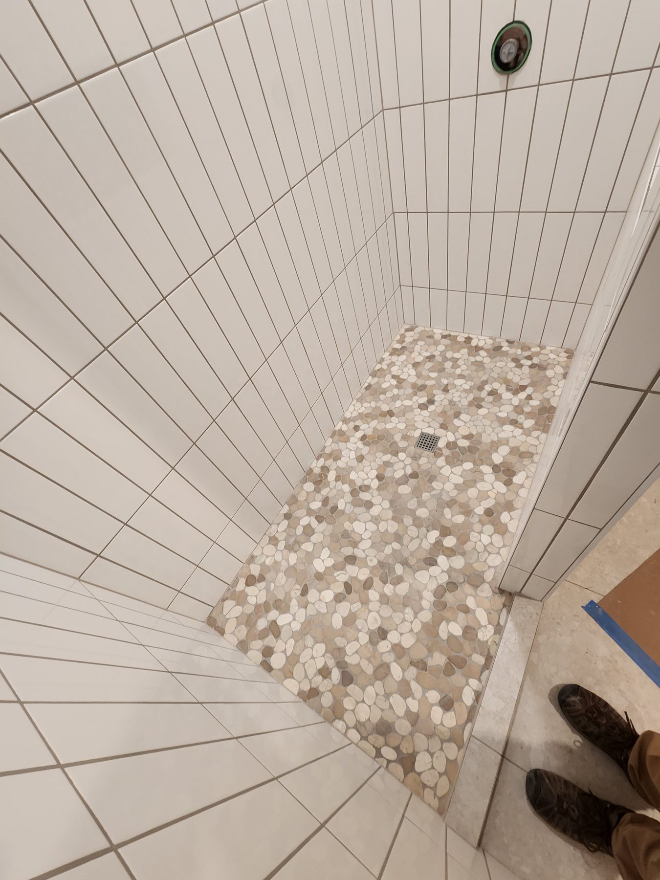 Custom-cut shower floor tile with pebble mosaic inset