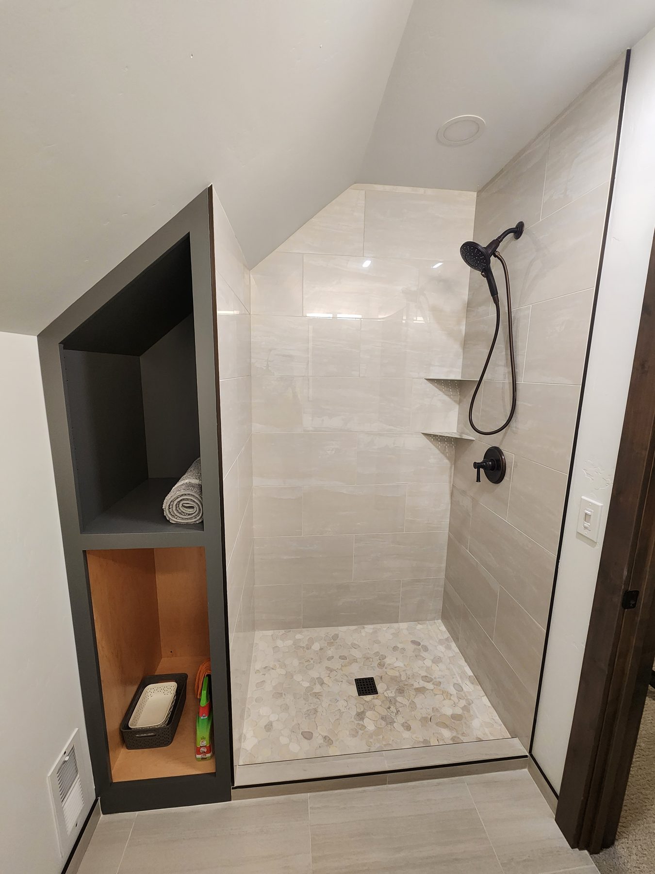 Walk-in shower with built-in niche shelving and matte black fixtures