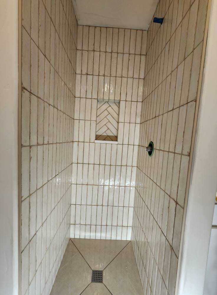Walk-in shower with built-in tile niche shelves for shampoo storage